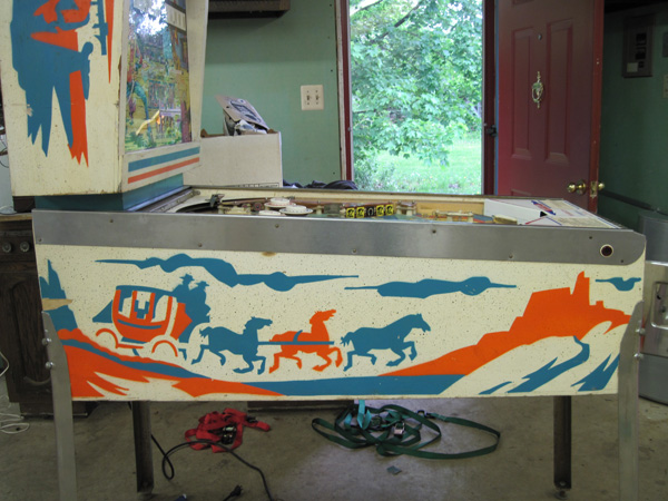 The lower side art, a n image of a stagecoach driven by three horses into a mountainous landscape.